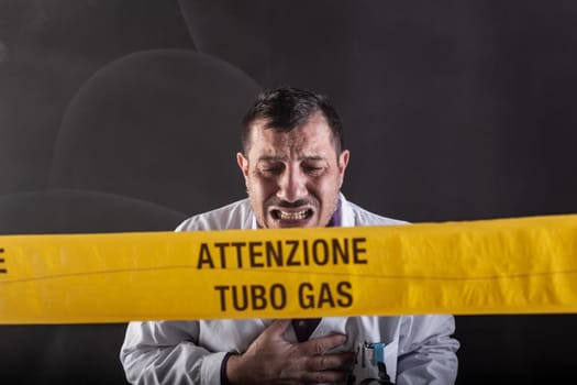 A medical engineer intoxicated by gas during the gas leaks crisis. On the yellow tape the written notice "attention gas tube"