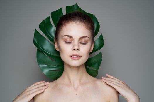beautiful woman clean skin palm leaf health cosmetics spa treatments. High quality photo