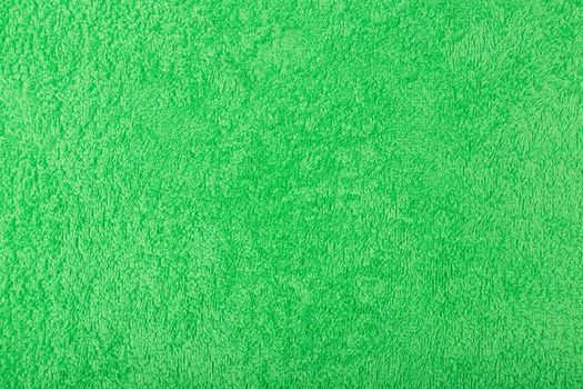 Green fuzzy and fluffy towel fabric close up. Fleece cozy shower towel background with space for text