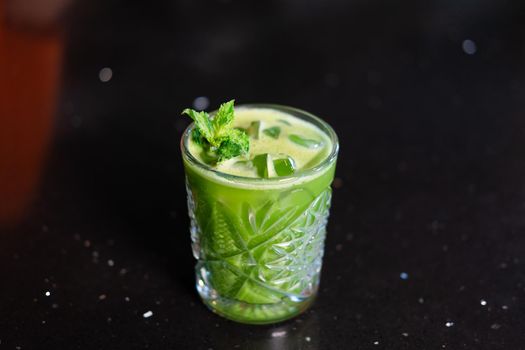 matcha cocktail or tea or latte with ice and mint isolated on black background. modern drinks. trendy cocktail.