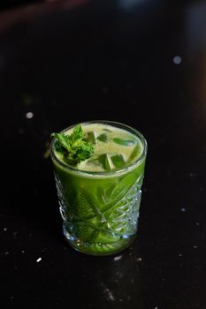 matcha cocktail or tea or latte with ice and mint isolated on black background. modern drinks. trendy cocktail.