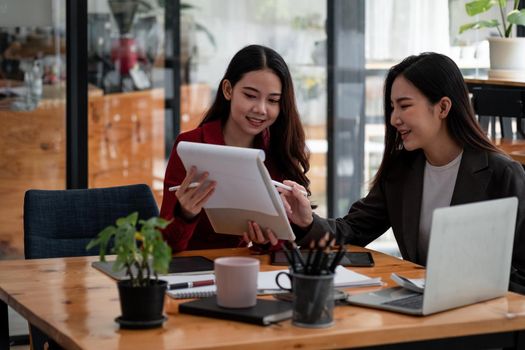 Business People Planning Strategy Analysis from financial document report, two asian female working together at office.