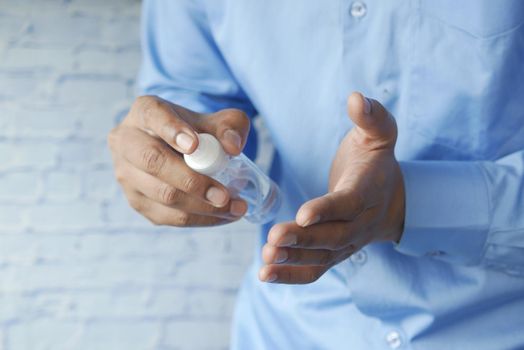 close up of young man hand using hand sanitizer spray