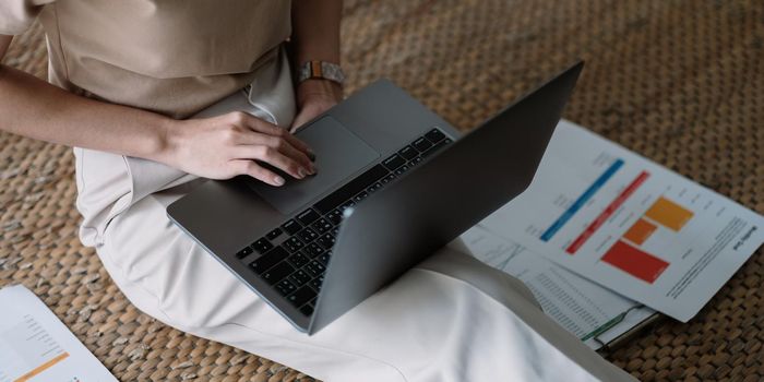 Close up Business woman using calculator and laptop for do math finance on wooden desk in office and business working background, tax, accounting, statistics and analytic research concept