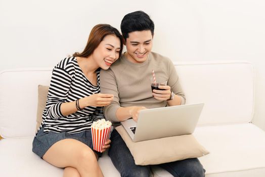 Young couple watching movie on laptop at home