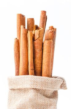 Cinnamon sticks in sag bag on white background