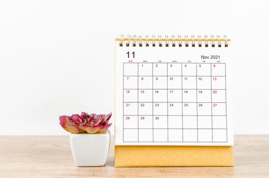 The November desk calendar 2021 on wooden background.