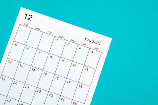 Close up December 2021 calendar sheet on green background.