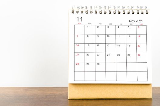 November desk calendar 2021 on wooden background.