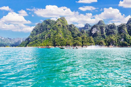 Wooden Thai traditional long-tail boat on a lake with mountains at Ratchaprapha Dam or Khao Sok National Park, Surat Thani Province, Thailand