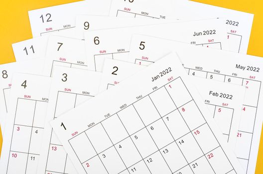 Many blank monthly 2022 calendar sheet on yellow background.