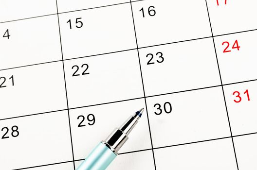 The pen on a blank calendar for your text or message.