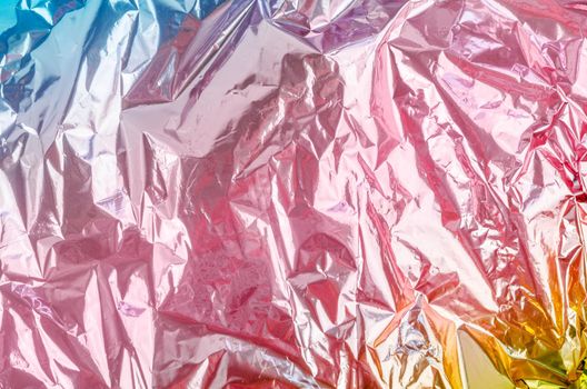 Colourful foil background with shiny crumpled surface for texture background.