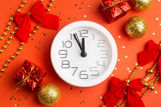 A clock in a New Year's layout on a red background. New Year's gifts. An article about the New Year and Christmas. It's almost 12 o'clock