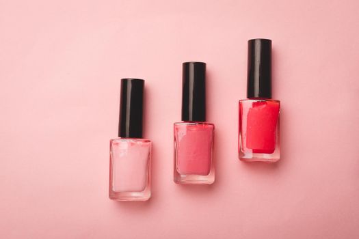 Pink nail polish on a pink copy space background. An article about nail polishes. Gel polish. An article about cosmetics. Decorative cosmetics . Pink background