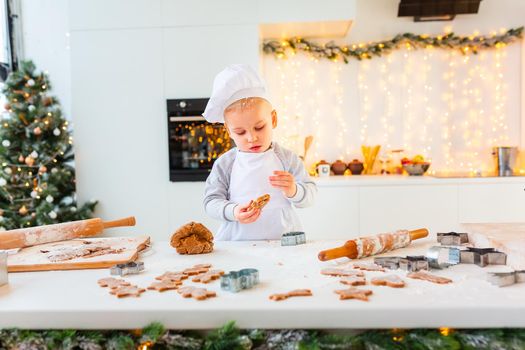 Cute little boy making gingerbread, cutting cookies of gingerbread dough. Christmas bakery. Festive food, cooking process, family culinary, Christmas and New Year traditions concept