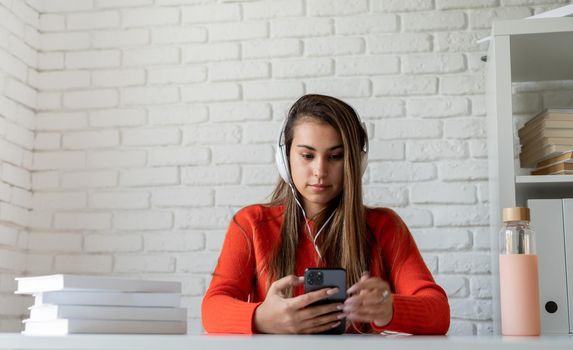 Social media. Young caucasian woman listening to the music using mobile