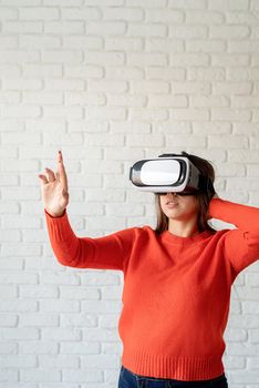 Smile happy woman getting experience using VR-headset glasses of virtual reality at home much gesticulating hands