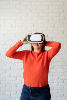 Smile happy woman getting experience using VR-headset glasses of virtual reality at home much gesticulating hands