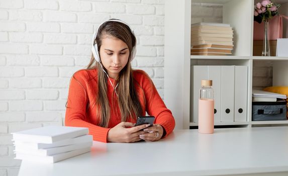 Social media. Young caucasian woman listening to the music using mobile