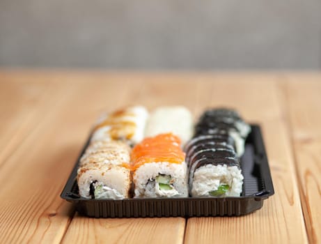 Making sushi and rolls at home. Sushi with seafood, salad and white rice. Food for family and friends. A set of different rolls and sushi on a tray.