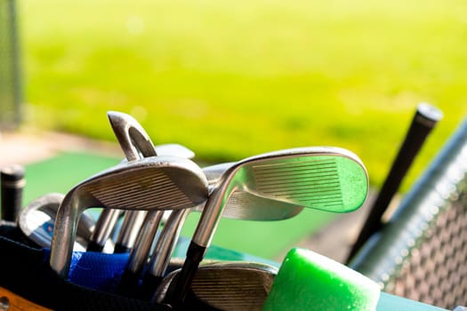 Golf clubs drivers over green field background Golf gear