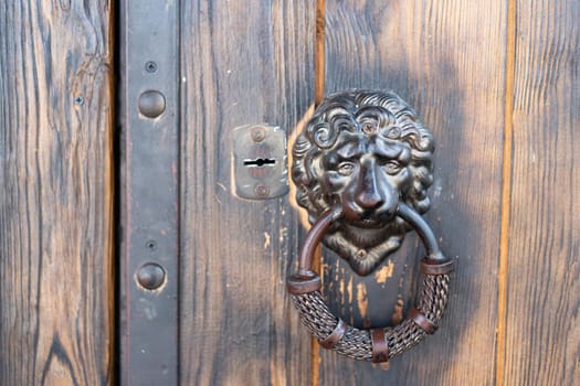 Lion head door handle on classic vintage door with copy space Old dirty doorknoob