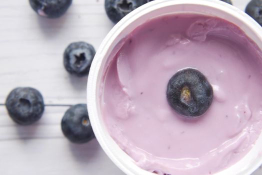 close up of fresh yogurt with blue berry in a bowl .