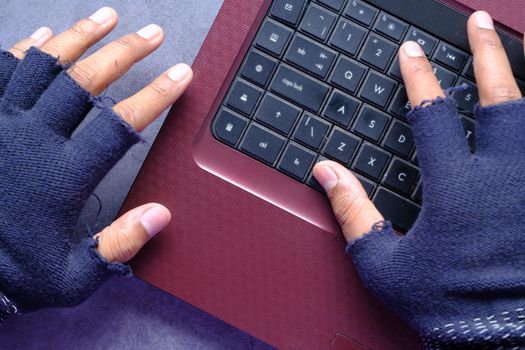 hacker hand stealing data from laptop top down.