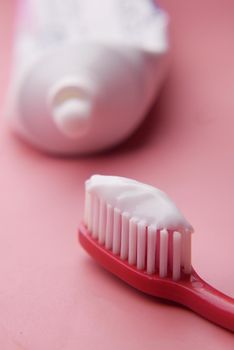 tooth brush and paste on pink ,