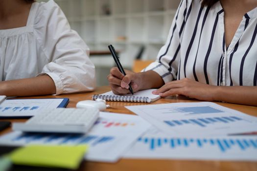 close up business woman taking note, group of business people working with accounting financial.