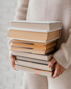 close up hands holding books stack. High resolution photo
