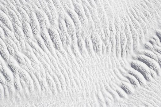 Gray and white texture of Pamukkale calcium travertine in Turkey, diagonal pattern, close-up.