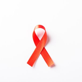 Red bow ribbon symbol HIV, AIDS cancer awareness with shadows, studio shot isolated on white background, Healthcare medicine concept, World AIDS Day