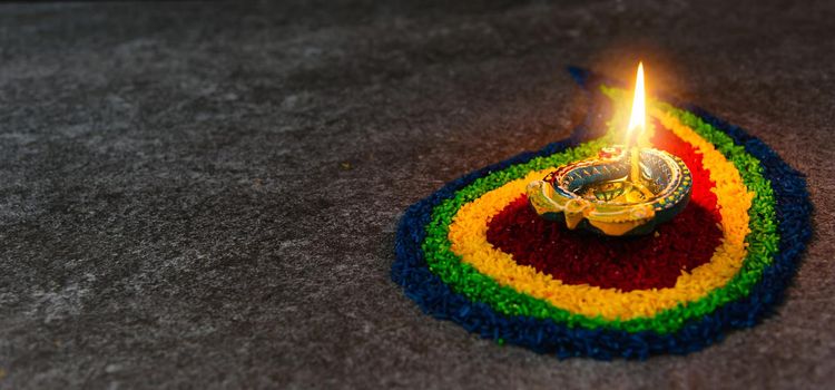 Close up clay lit light a fire already on Diya or oil lamp on concrete background, Decoration of Hinduism rangoli, Happy celebration Deepavali, or Diwali Indian festival concept