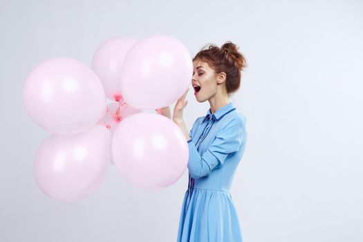 cheerful woman in a blue dress pink balloons holiday birthday. High quality photo