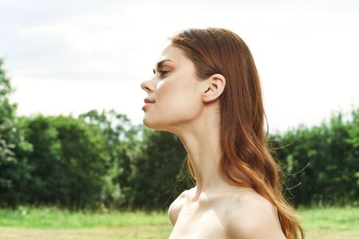 pretty woman in a field outdoors bare shoulders clear skin cropped view. High quality photo