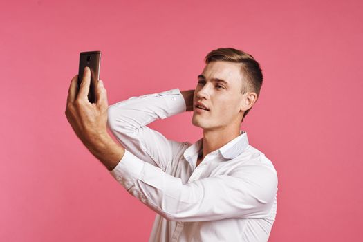 businessmen with a phone in hand fashion posing pink background. High quality photo