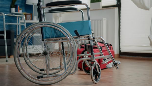 Nobody in nursing home room with transportation support for patients. Empty space with wheelchair and walk frame for medical assistance, healthcare and rehabilitation