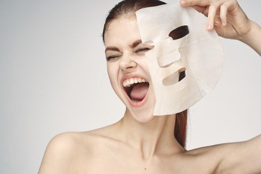 woman with bare shoulders and face mask skin care cosmetics. High quality photo