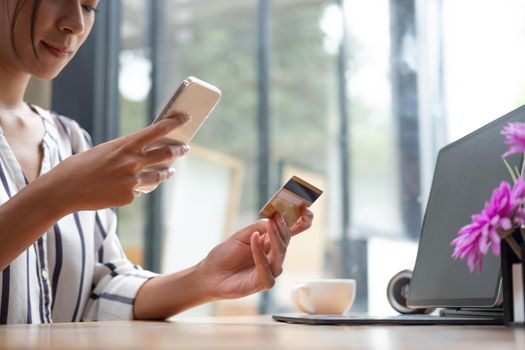 Young asian woman holding credit card and using tablet computer. Businesswoman working at home. Online shopping, e-commerce, internet banking, spending money, working from home concept