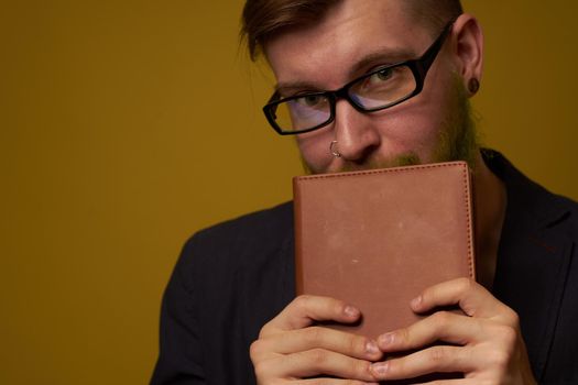 bearded man in a black jacket with a book in his hands education. High quality photo