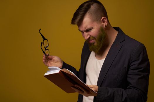 bearded man in a black jacket with a book in his hands education. High quality photo