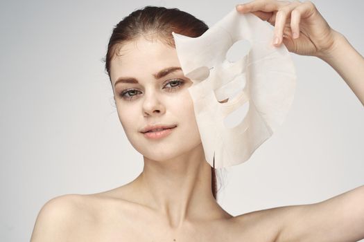 woman with bare shoulders and face mask skin care cosmetics. High quality photo