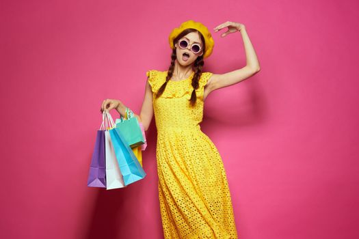 cheerful woman in a yellow hat Shopaholic fashion style pink background. High quality photo