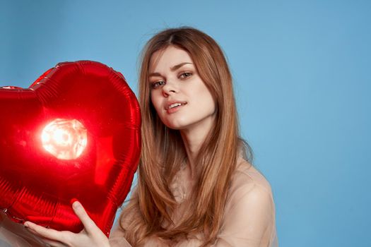 pretty woman red heart in the hands of the balloon blue background. High quality photo