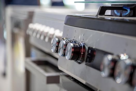 handles of a gas or electric stove, close-up, side view, soft focus