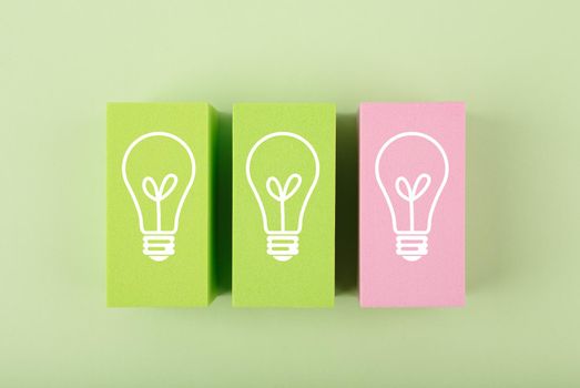 Concept of idea, creativity, start up or brainstorming. White drawn bulbs on green and pink toy blocks against bright green background 
