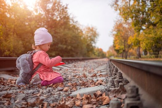 busy child. a toddler playing on an abandoned railroad track.