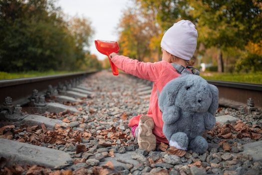 road repair. child shoveling railway tracks.